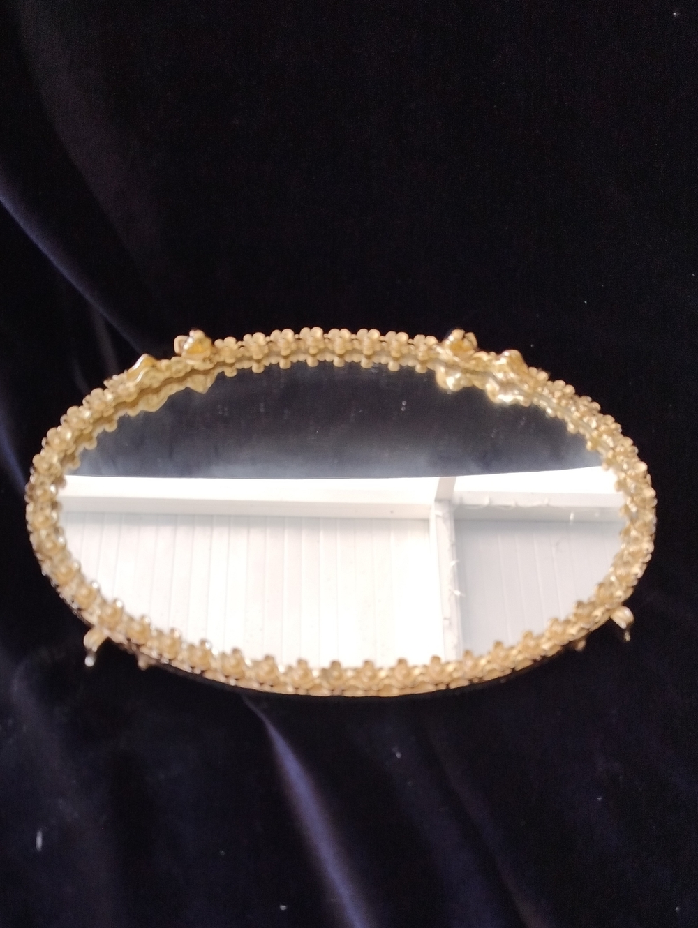 Vintage oval vanity tray features a mirror surface surrounded by a filigree